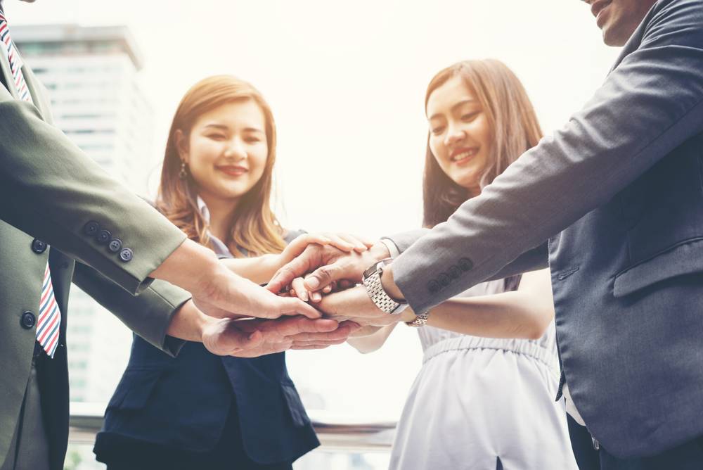 Crafting the Perfect Job Ad: A Guide to Attracting Top Talent 2 close up business people hands together teamwork concept scaled