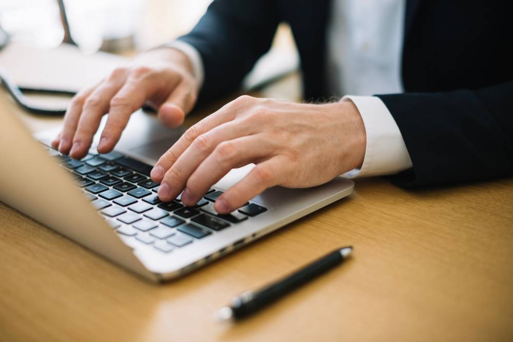 5 Ways to Structure a Resume to Get You Noticed 1 man typing laptop office scaled